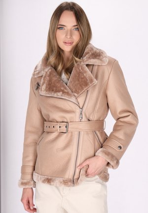 Beige Kunstlederjacke mit einem plüschigen braunen Pelzkragen, tailliertem Bund, Reißverschluss vorn und strukturierten Ärmeln. Akzente aus silbernem Metall.