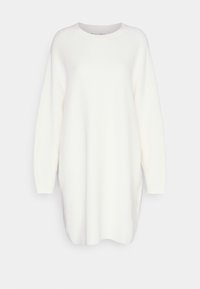 Robe pull à manches longues en maille côtelée blanche, avec un col rond et des fentes latérales pour faciliter les mouvements. Texture douce et coupe ample.