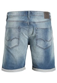 Pantalones cortos de mezclilla en azul claro con un diseño desvaído, dobladillos enrollados y costuras en contraste. Presenta dos bolsillos traseros con acentos curvados.