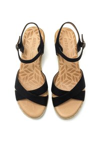 Sandalias de ante negro con tiras entrecruzadas, hebilla ajustable en el tobillo y plantilla texturada color tostado con un patrón de hojas.