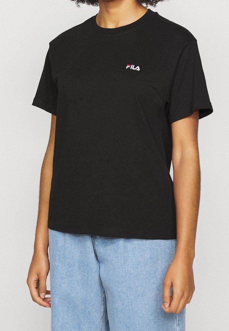 Svart bomullströja med rund hals och korta ärmar. Har en broderad FILA-logotyp i vitt och rött på bröstet. Avslappnad passform.
