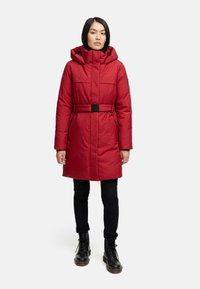Red padded coat with a belt, hood, and two front pockets. Features a sleek design and a matte texture. Black hardware accents.