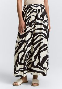 Maxi-Rock mit einem Schwarz-Weiß-Zebra-Muster, aus leichtem Stoff gefertigt, mit einem elastischen Bund und einer fließenden Silhouette.
