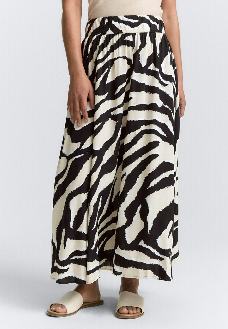 Maxi-Rock mit einem Schwarz-Weiß-Zebra-Muster, aus leichtem Stoff gefertigt, mit einem elastischen Bund und einer fließenden Silhouette.