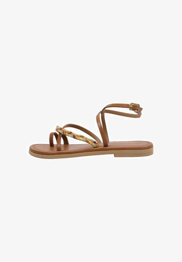 Brown leather sandal with thin straps, featuring a colorful braided accent. Flat sole with a minimalistic design and a buckled ankle strap.