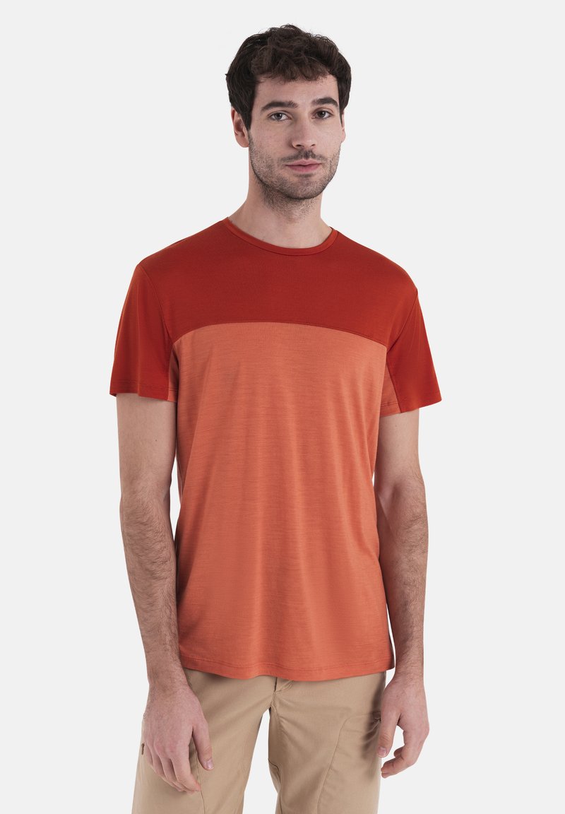 T-shirt a maniche corte in sfumature di rosso e arancione, con una texture liscia e scollatura arrotondata.