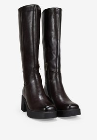 Botas de cuero lisas de color marrón oscuro, de altura hasta la rodilla, con cremallera lateral, tacón cuadrado y punta redonda, y suela texturada.