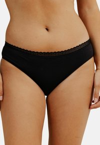 Sous-vêtements en coton noir avec une bordure en dentelle festonnée sur la taille, présentant un design simple et une texture lisse.