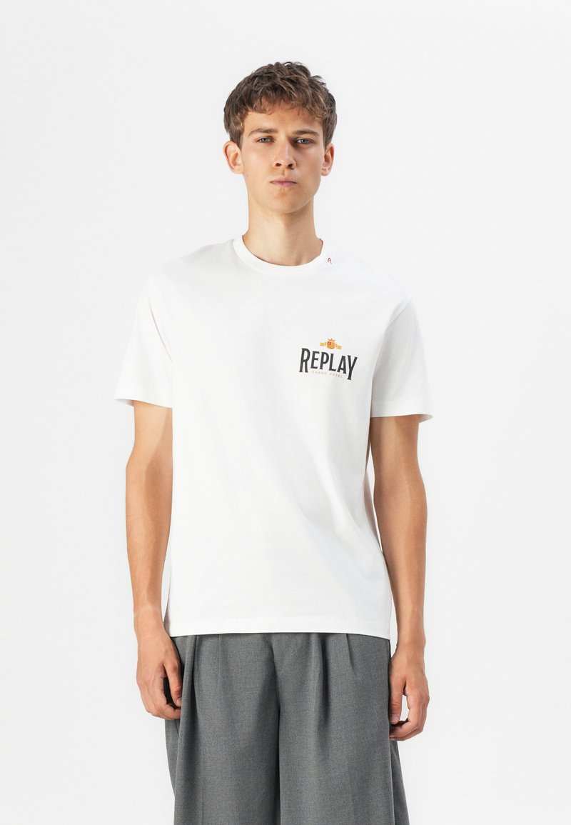 Hvit bomull T-skjorte med svart "REPLAY" logo på brystet og en liten logo på skulderen. Klassisk rund hals-design.