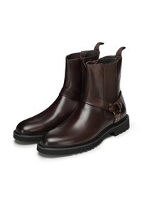 Bottines en cuir marron à finition lisse, avec fermetures éclair latérales, panneaux élastiques et une bride avec ferrures métalliques. Semelle en caoutchouc texturée.