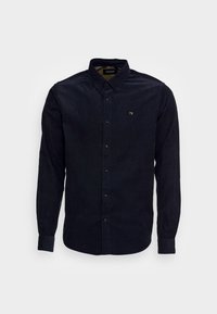 Camisa de botón azul marino hecha de un tejido suave, con cuello, mangas largas y un pequeño logotipo bordado en el pecho.