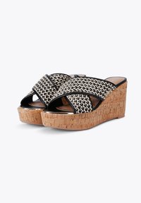 Wedge sandalen met een zwart en beige geweven bovenwerk, kurken plateauzool en een kruisriemontwerp. Glad oppervlak met contrasterende accenten.
