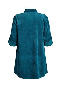 Zielona koszula z korduroju z kołnierzykiem, długimi rękawami podwiniętymi, o gładkiej fakturze. Posiada prosty krój z zaokrąglonym dołem.