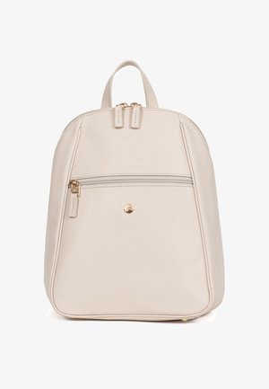 Sac à dos en cuir couleur crème avec une poche avant zippée, une fermeture à double zip en haut et un petit emblème rond doré.