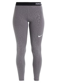 Szare legginsy z subtelnym wzorem w zwierzęce motywy, wykonane z elastycznego materiału. Posiadają czarną elastyczną talię z logo "NIKE PRO" oraz białym znakiem swoosh.