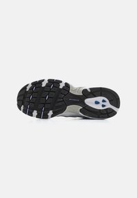 Black rubber outsole with white and light blue accents, featuring grooves for traction and a smooth, curved design. "New Balance" logo visible.
