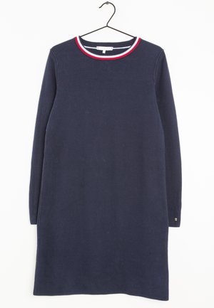 Marineblauwe jurk met lange mouwen van gebreide stof, voorzien van een ronde halslijn met rode en witte bies, zijsplitten en een labeldetail op de mouw.