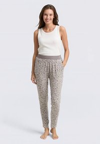 Lekka, bezrękawnikowa biała bluzka z okrągłym dekoltem w połączeniu z szarymi, zwężanymi spodniami w panterkę, wyposażonymi w elastyczny pas i boczne kieszenie.