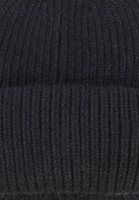 Berretto nero lavorato a maglia realizzato in filato morbido e texturizzato, caratterizzato da un motivo a costine e con risvolto nella parte inferiore.
