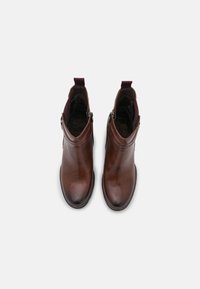 Bottines en cuir marron avec une finition lisse, bout rond et fermeture éclair sur le côté. Doublées de tissu doux et dotées d'une languette.
