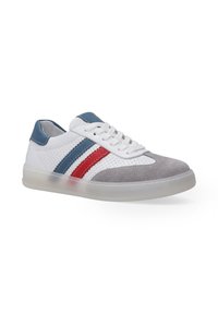Weiße Sneaker mit grauem Wildlederzeh, blauen Akzenten und roten und blauen Streifen an der Seite. Verfügt über ein perforiertes Design und eine transparente Sohle.