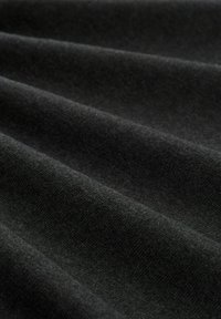 Donkergrijze stof met een zachte, gladde textuur, die subtiele plooien en een uniforme kleur vertoont. Het materiaal lijkt licht en buigzaam.