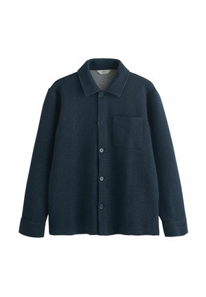 Mörkblå skjorta med knappar, tillverkad av textil med struktur. Har krage, en bröstficka och långa ärmar med manchetter.
