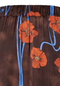 Zwarte stof met een bloemenpatroon van feloranje klaprozen en blauwe stelen op een gladde textuur, verzameld bij de tailleband.
