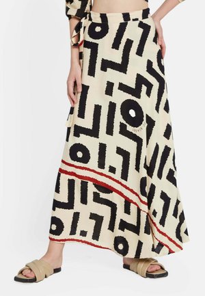 Falda maxi en crema con un audaz patrón geométrico negro. Presenta una franja de acento roja en el dobladillo. Fabricada en tejido ligero.