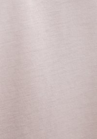 Gros plan sur un tissu beige doux avec une texture tricotée fine et uniforme et de subtiles lignes horizontales.