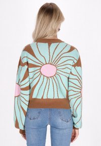 Maglione lavorato a maglia con uno sfondo turchese chiaro e motivi floreali marroni e rosa. Design corto con orlo a coste e maniche lunghe.
