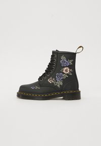 Svart läderankelstövel med blommig broderi i lila och rosa. Inkluderar svarta snören, gula sömmar och en dragflik.