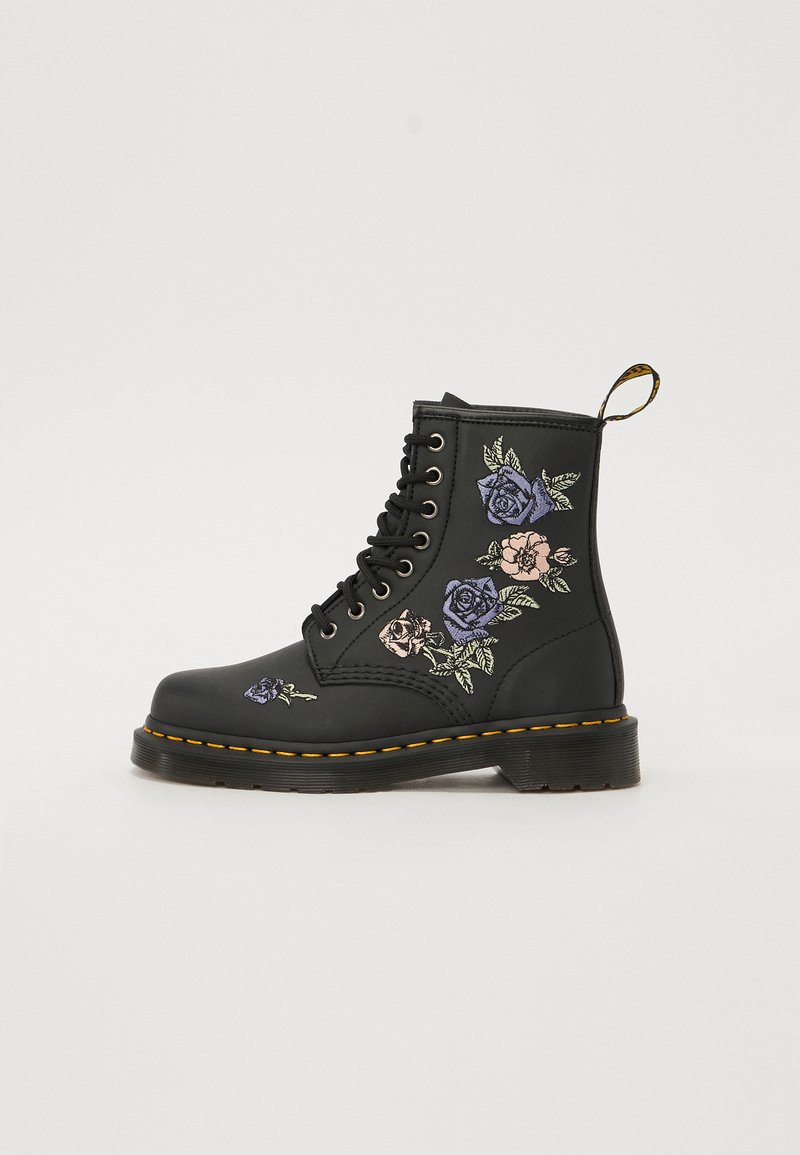 Black leather ankle boot featuring floral embroidery in purple and pink. Includes black laces, yellow stitching, and a pull tab.