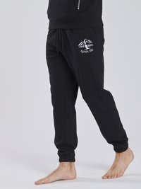 Schwarze Sweatpants mit elastischem Bund und Bündchen, die auf der Vorderseite ein weiß gesticktes Gebirge und das "Après Ski"-Logo zeigen.