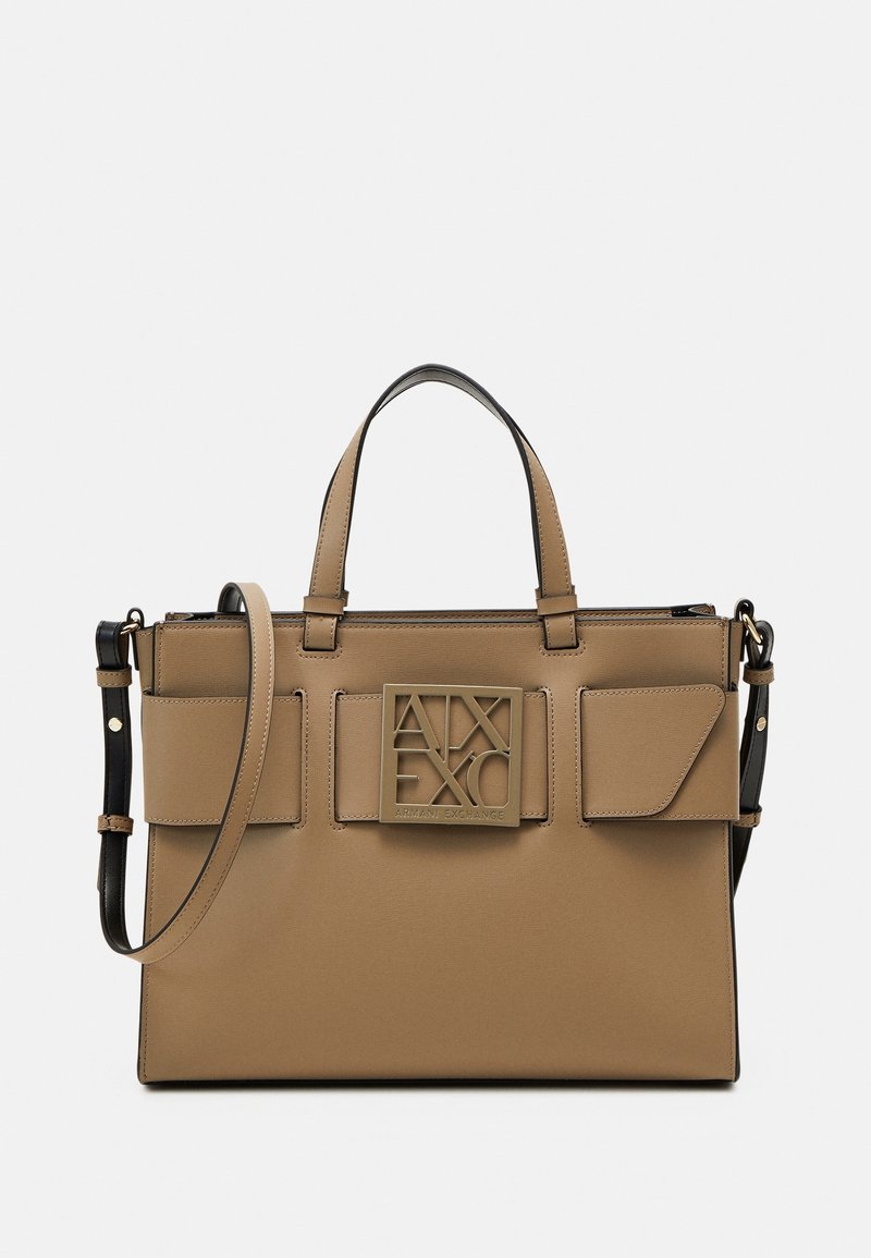 Béžová syntetická kabelka s dvojitými horními rukojetmi, odnímatelným ramenním popruhem a předními kapsami s klopou. Má zlatou logo plaketou a čisté linie.