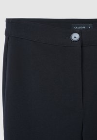 Schwarze Hose mit glatter Textur, ausgestattet mit einem Knopfverschluss, einem flachen Bund und einer Faltenlegung an der Vorderseite. Mit der Marke „CALLIOPE“.