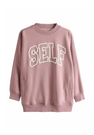 Różowa, oversize’owa bluza z prążkowanymi mankietami i dekoltem. Na przodzie miękkie, białe haftowane napisy "SELF". Kieszenie boczne w komplecie.