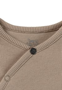 Beige geribbelde lange mouwen top met een V-hals, voorzien van een zwarte knoopsluiting en een gestructureerde afwerking. Subtiele logo-afdruk aan de binnenkant.