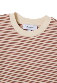 Camiseta de manga corta con base crema y rayas horizontales en color óxido y rosa suave; escote redondo con ribete cosido y etiqueta de tela.