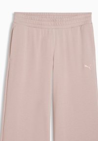 Pantalon rose clair à taille élastique avec poches latérales et petit logo Puma sur la cuisse droite supérieure.