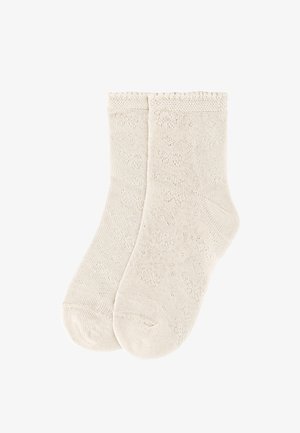 Par de calcetines tobilleros de punto en color beige claro con un patrón sutil similar a encaje y bordes elásticos, mostrados extendidos sobre un fondo blanco.