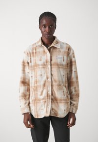 Fleecejakke i beige og brun rutete mønster, med krage, knappelukking og frontlommer. Myk tekstur og avslappet passform.