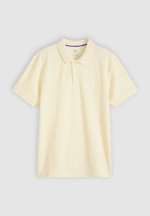 Lichtgeel polo-shirt met korte mouwen, kraag en twee knopen, weergegeven op een lichtgrijze achtergrond.