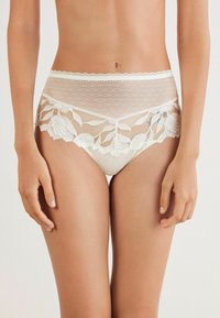 Witte kanten hipsteronderbroek met een doorzichtige polka dot mesh overlay en bloemenborduursel langs de tailleband en beenopeningen.