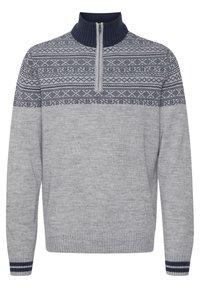Grå genser med høyt hals med glidelås, med et marineblått fair isle-mønster over brystet, og ribbestrikkede mansjetter med marineblå striper.