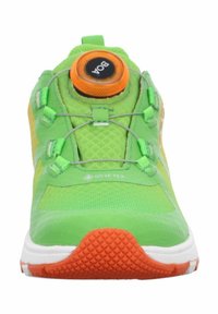 Zapatillas deportivas de Gore-Tex en verde con parte superior texturizada, sistema de cierre BOA y un dial circular naranja, con suela naranja antideslizante.