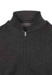 Schwarze Zip-Jacke mit Stehkragen, aus strukturiertem Stoff. Verfügt über einen silbernen Reißverschluss und eine dezente Markenkennzeichnung auf dem Innenschild.