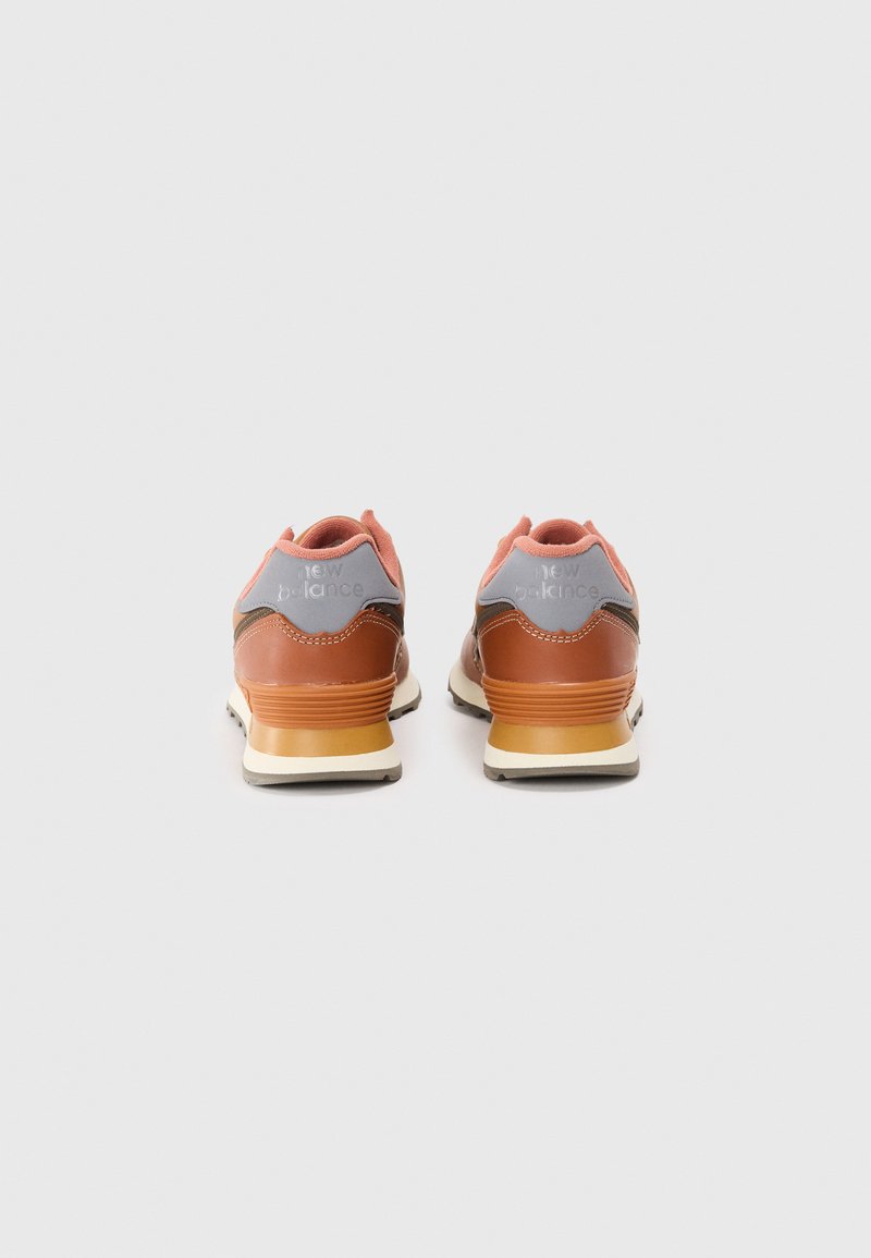 Brune lædersneakers med lyserøde og grå accenter, der har en tekstureret overflade, en polstret krave og en polstret sål.