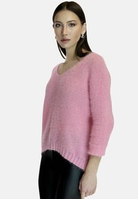 Maglione rosa lavorato a maglia con vestibilità ampia, scollo ampio e maniche a tre quarti. Texture morbida e orlo posteriore leggermente più lungo.