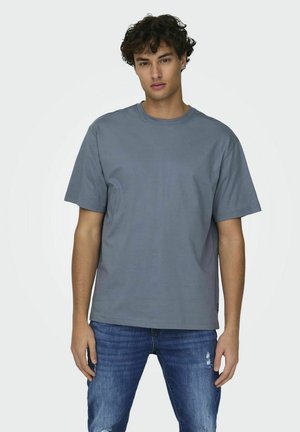 Gray cotton t-shirt with a round neck, short sleeves, and a relaxed fit. Worn with blue distressed jeans, showcasing a casual look.